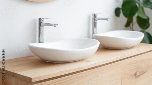 Modern bathroom with sleek white sinks and wooden countertop highlighting contemporary design elements.