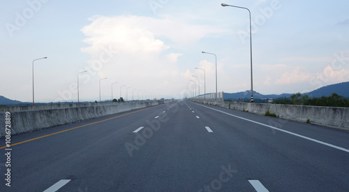 Panoramic city skyline and mountain with empty asphalt road at sunset