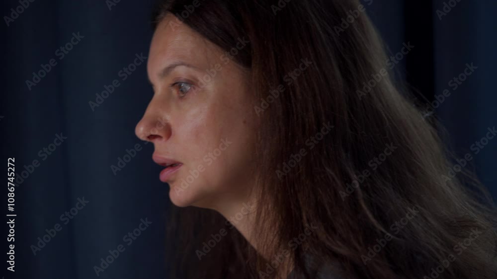 Adult 44 year old woman working at desk on computer at home, concentrated face of woman looking attentively at laptop screen. Woman studying document, saying something. Adult 44 year old woman working at desk on computer at home, concentrated face of woman looking attentively at laptop screen. Woman studying document, saying something.
