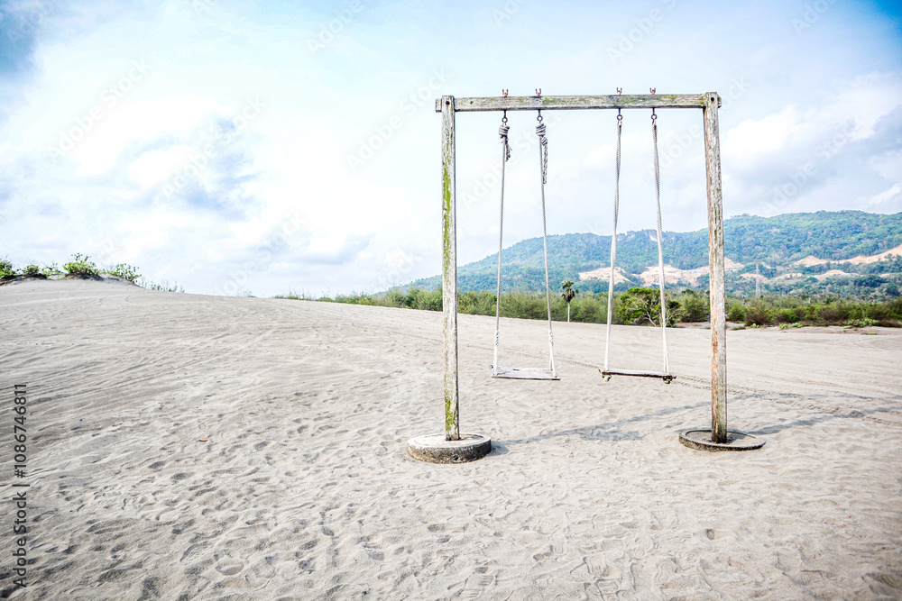 Empty aesthetic wooden swing on sand beach Empty aesthetic wooden swing on sand beach