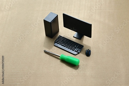 Miniature  Computer setup on a brown cardboard surface with desktop tower, monitor, keyboard, mouse