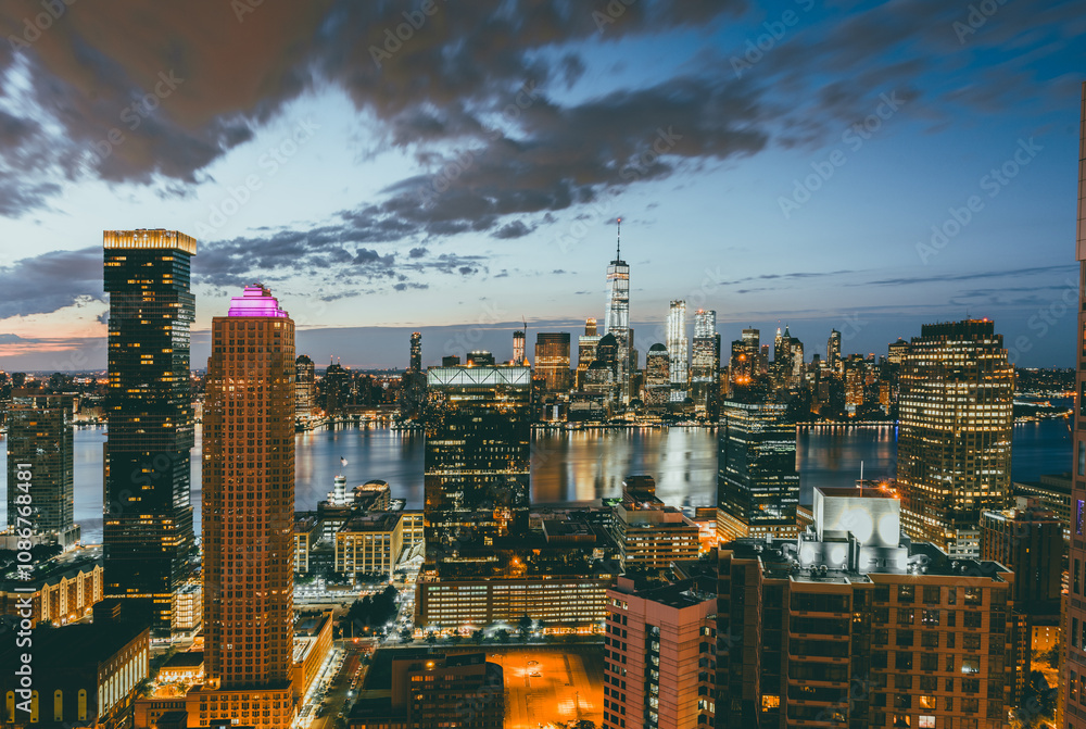Naklejka premium Rooftop view of the New York City skyline during sunrise with purple clouds from Jersey City, New Jersey.