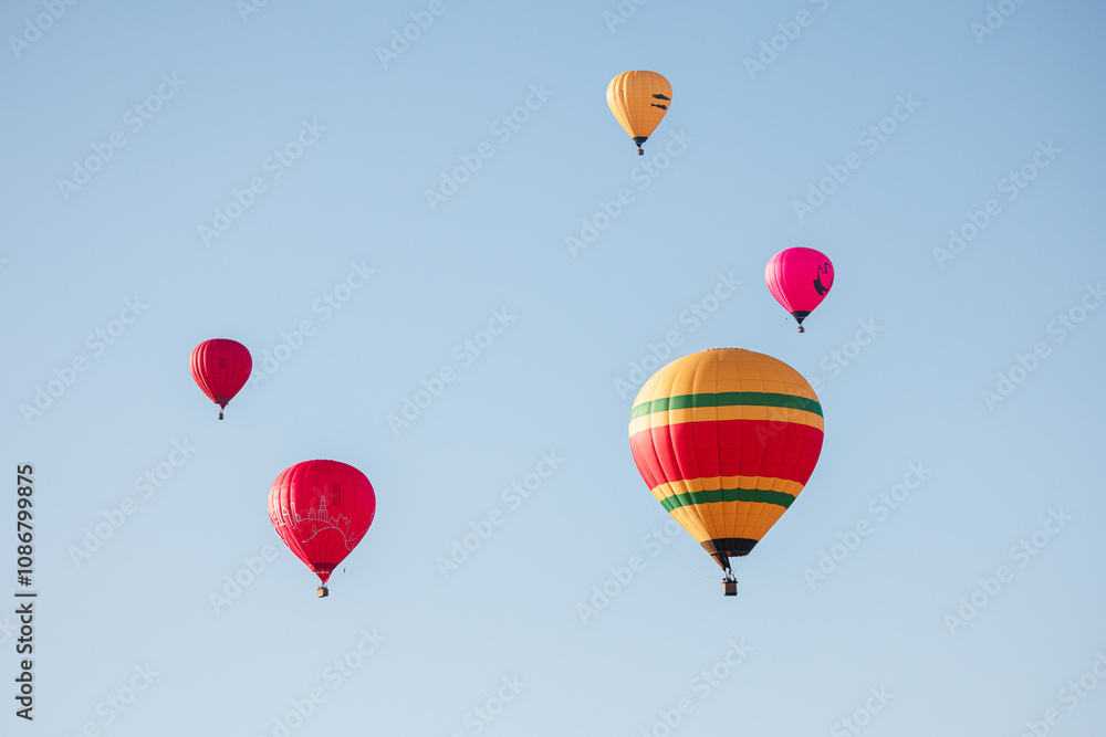 Fototapeta premium A Symphony in the Sky: Colorful Hot Air Balloons Dancing Among the Clouds at Sunrise.