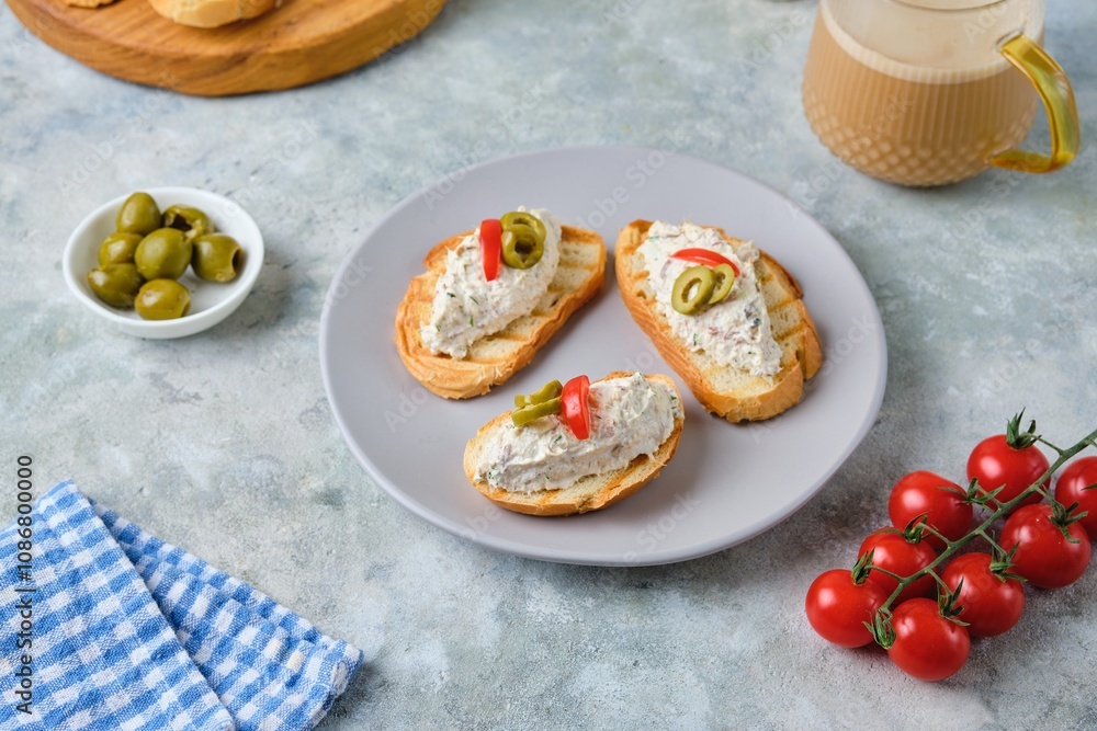 Cold appetizer, mackerel rillettes on white bread toasts on ceramic plate on gray concrete background. Recipes fish, seafood. Cold appetizer, mackerel rillettes on white bread toasts on ceramic plate on gray concrete background. Recipes fish, seafood.
