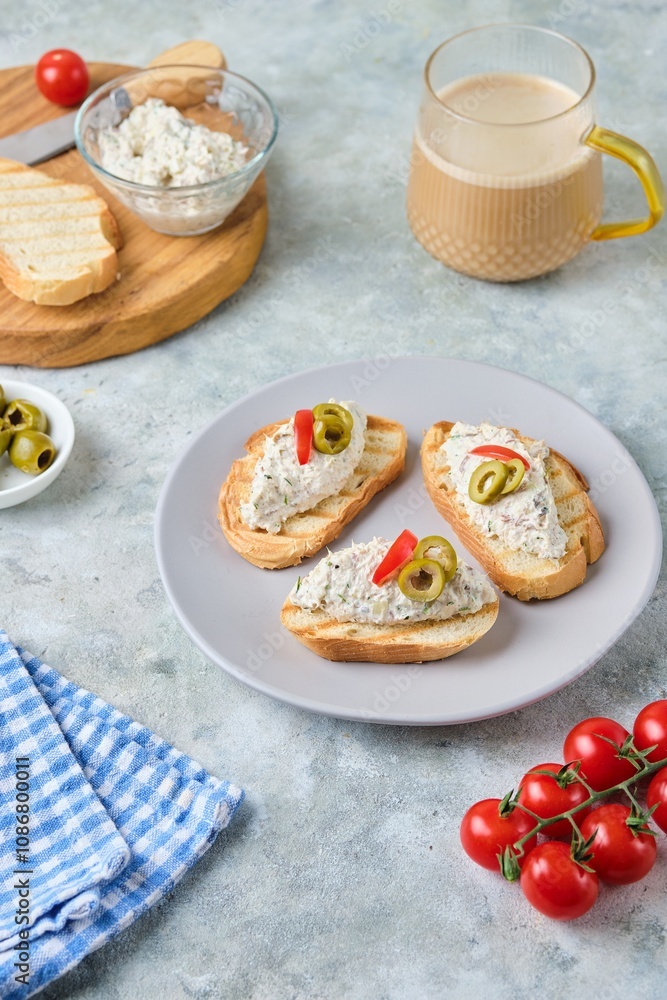 Cold appetizer, mackerel rillettes on white bread toasts on ceramic plate on gray concrete background. Recipes fish, seafood. Cold appetizer, mackerel rillettes on white bread toasts on ceramic plate on gray concrete background. Recipes fish, seafood.