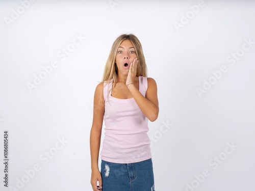 Shocked Beautiful teen girl wearing sleeveless t-shirt looks with great surprisment being very stunned, astonished with unexpected news, Facial expressions concept.