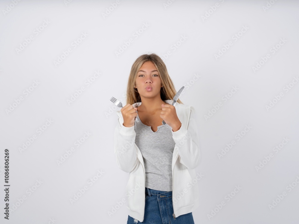 hungry Beautiful teen girl wearing white jacket holding in hand fork knife want tasty yummy pizza pie hungry Beautiful teen girl wearing white jacket holding in hand fork knife want tasty yummy pizza pie