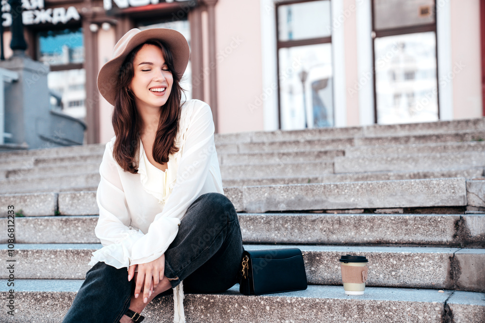 Portrait of young beautiful smiling hipster woman in trendy summer white blouse and jeans. Carefree woman posing in the street in sunny day. Positive model outdoors. Cheerful and happy Portrait of young beautiful smiling hipster woman in trendy summer white blouse and jeans. Carefree woman posing in the street in sunny day. Positive model outdoors. Cheerful and happy
