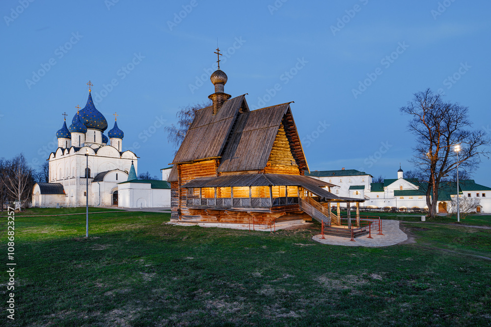 Fototapeta premium Sanctuary of Timeless Faith: A Wooden Church Embraced by the Majestic Stone Cathedral Beyond