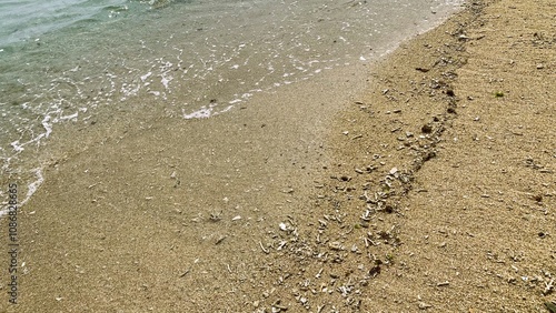 Small waves on a beach, Tiny waves lapped at the shore. Gentle ripples danced across the calm, shallow water. Kondang Merak Beach in Malang Indonesia photo