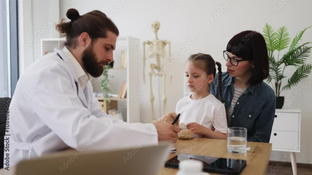 Caucasian male doctor examines young Caucasian girl with runny nose while mother looks on worriedly. Girl holds tissue to her nose in doctors office setting.