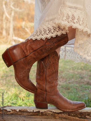 legs in western cowboy boots with vintage lace dress