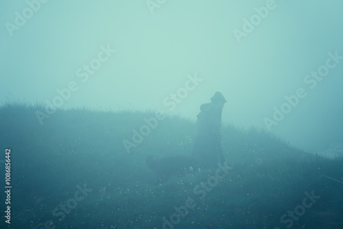 A farmer and his sheeps during a foggy and moody day