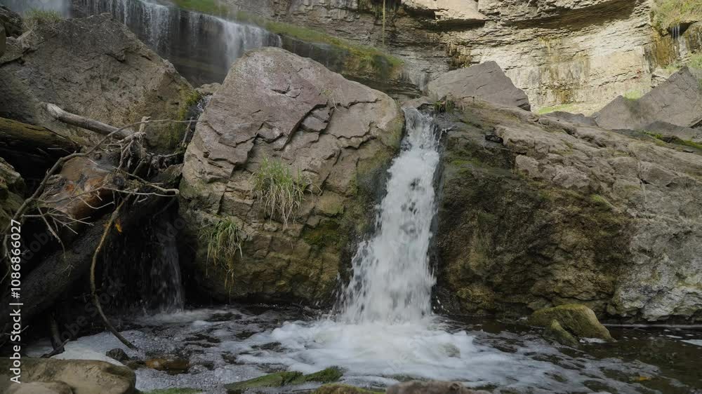 Water flows over rocks in a serene natural setting with mossy details and calming ambiance Water flows over rocks in a serene natural setting with mossy details and calming ambiance