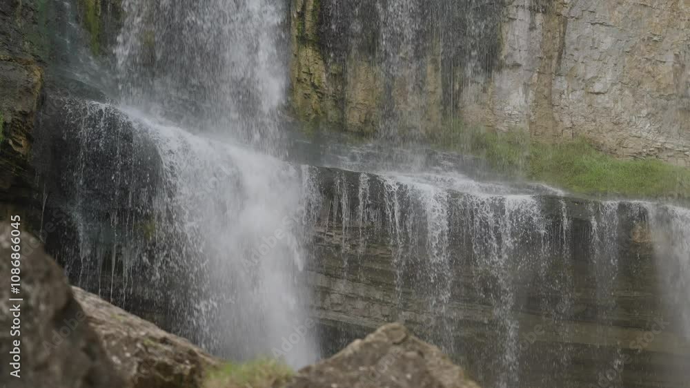 Water cascades down a rocky cliffside creating a peaceful natural waterfall scene Water cascades down a rocky cliffside creating a peaceful natural waterfall scene