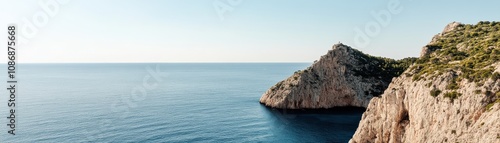 Stunning view of a rocky coastline meeting the serene blue ocean under a clear sky.