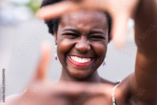 Happy young woman gesturing finger frame photo