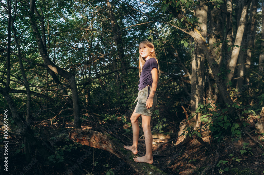 Happy girl standing on tree trunk in forest Happy girl standing on tree trunk in forest