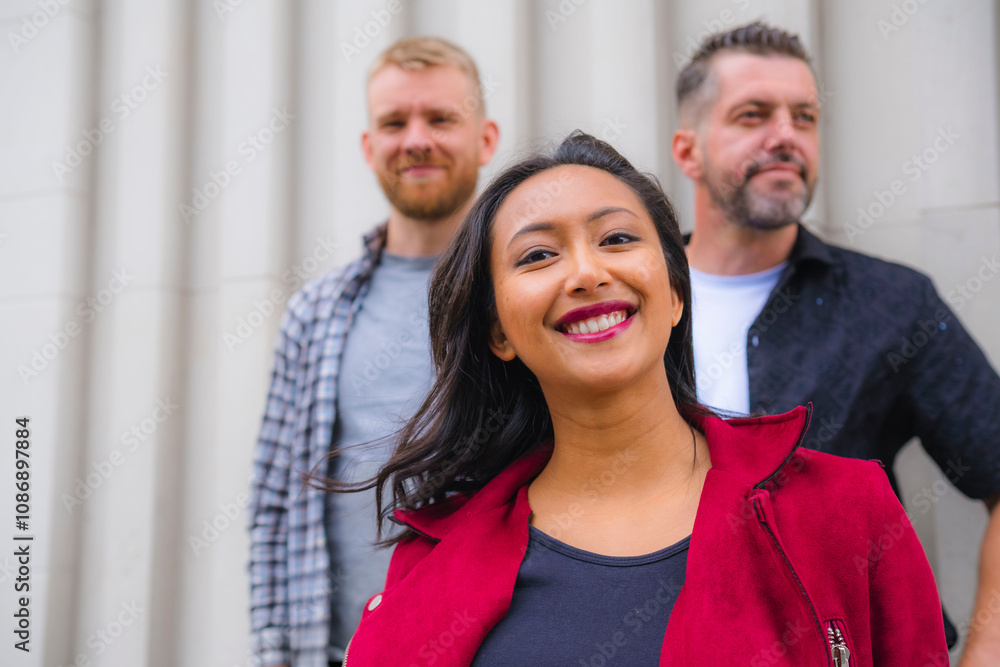 Happy woman standing with friends in front of wall Happy woman standing with friends in front of wall