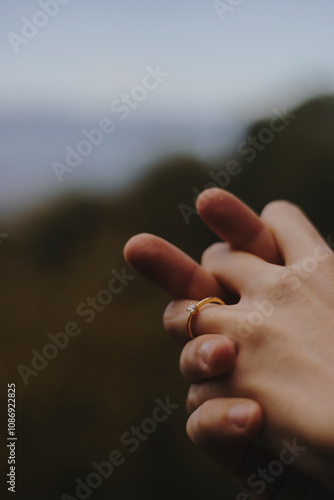 Two hands intertwined, one adorned with an engagement ring, symbolizing love, commitment, and a cherished moment.