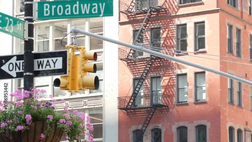 Broadway street road sign, Manhattan midtown architecture, New York City corner. Yellow traffic light. Flatiron district near Madison Square Park. Crossroad of 23 st., Bway and 5 Fifth avenue. One way
