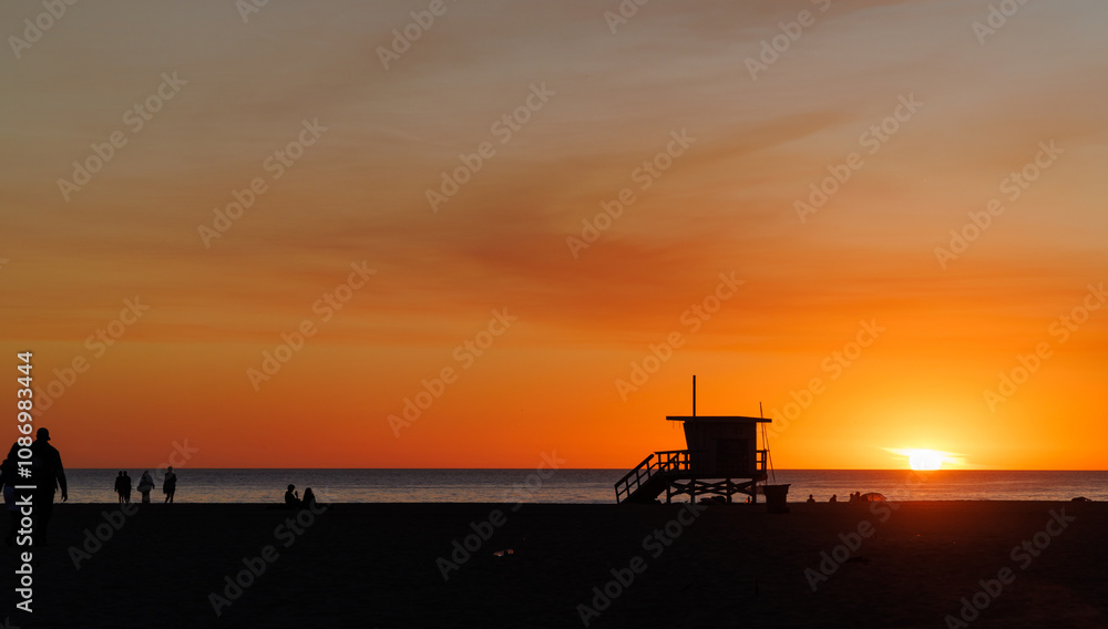 Los Angeles beach at sunset, featuring a lifeguard tower silhouette against a glowing orange and purple horizon Los Angeles beach at sunset, featuring a lifeguard tower silhouette against a glowing orange and purple horizon