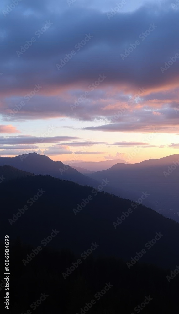mountains are silhouetted against a cloudy sky at sunset mountains are silhouetted against a cloudy sky at sunset