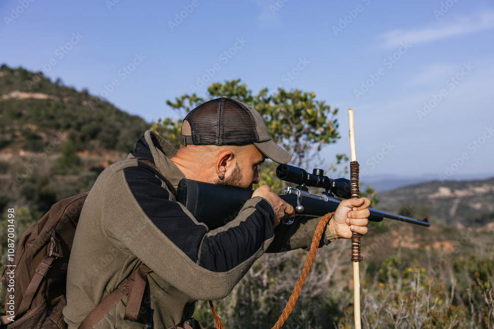Naklejka premium Hunter aiming with rifle in forest during hunt