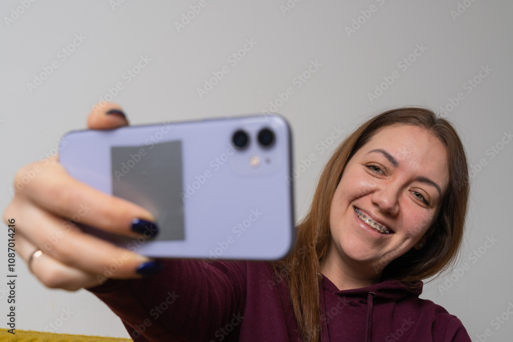 Woman wear braces using smartphone at home Woman wear braces using smartphone at home