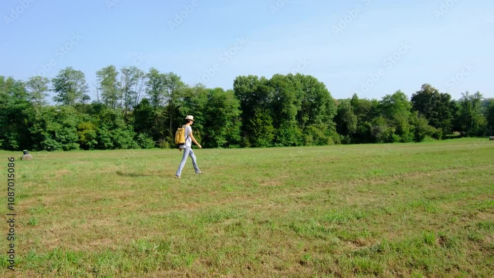 Woman hiking through a countryside landscape, surrounded by open fields, fresh air, and peaceful rural scenery. She enjoys the natural beauty and serenity of the outdoors. Woman hiking through a countryside landscape, surrounded by open fields, fresh air, and peaceful rural scenery. She enjoys the natural beauty and serenity of the outdoors.