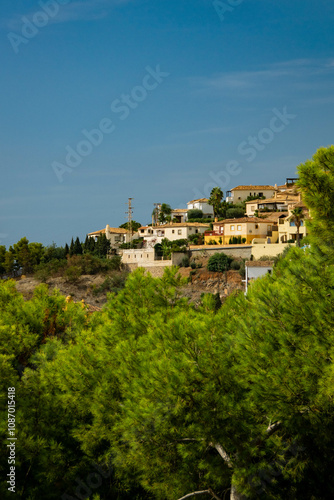 Beautiful little village in the mountains of Spain with light green trees