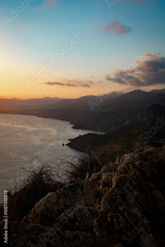 blue and orange beautiful sunset over the sea and green mountains in Spain 