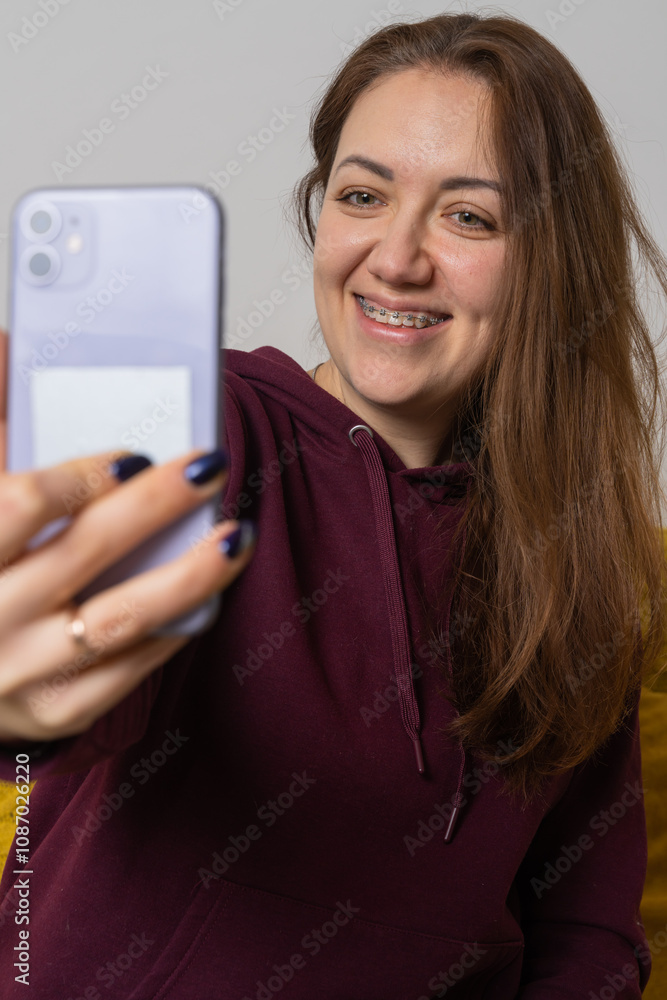Woman wear braces using smartphone at home Woman wear braces using smartphone at home