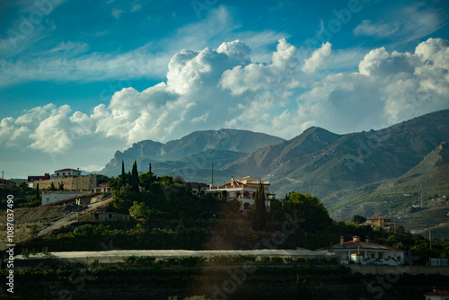 Panorama of the mountains in Andalucía, Spain with big incredible clouds and characteristic white and yellow houses