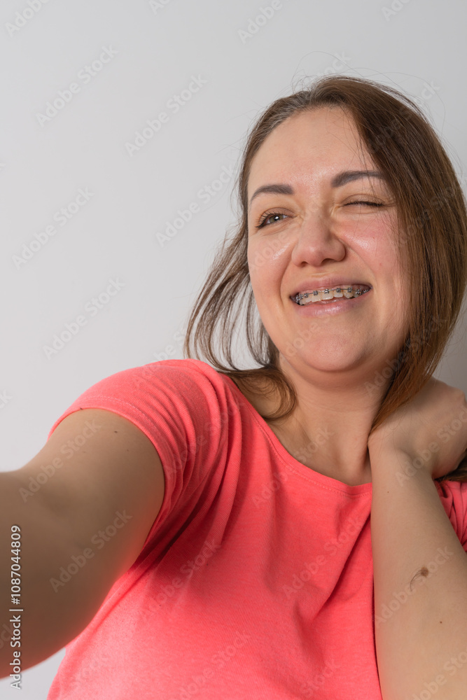 Fototapeta premium Woman wear braces using smartphone at home