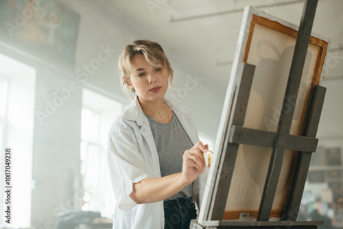 Woman painting in an art studio filled with natural light