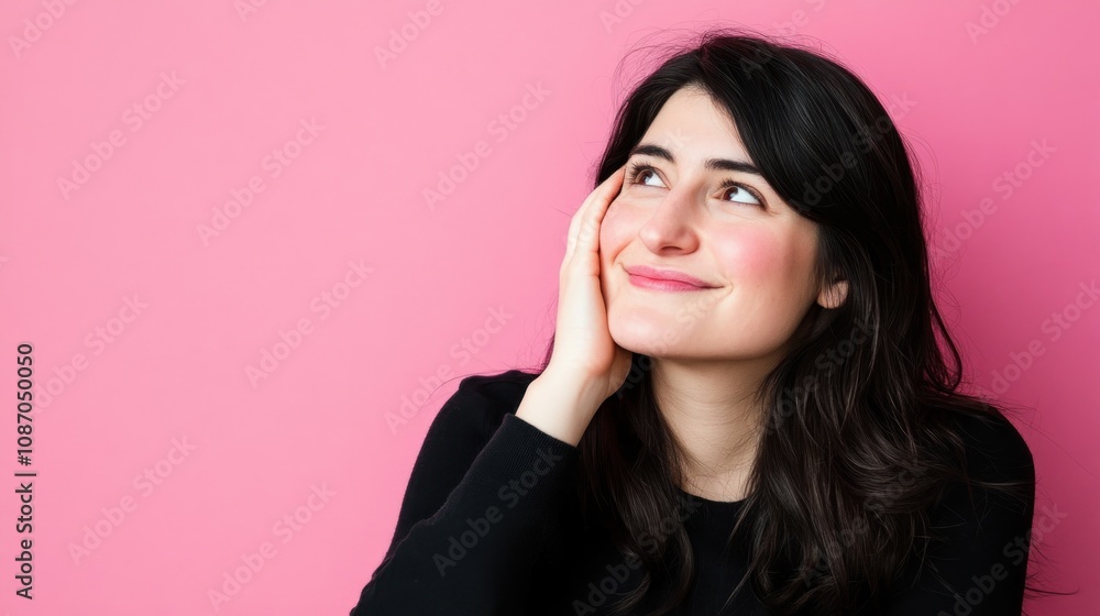 Woman smiling thoughtfully against a pink background. Woman smiling thoughtfully against a pink background.
