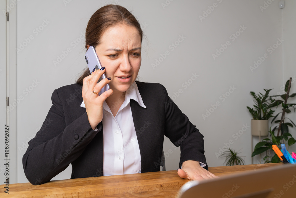 Young businesswoman with braces looks at her laptop screen. Young businesswoman with braces looks at her laptop screen.