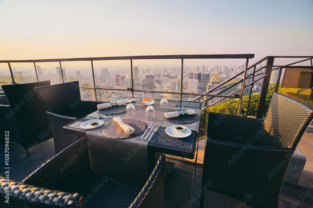 Fototapeta premium Table setting on roof top restaurant with megapolis view, Bangkok Thailand.