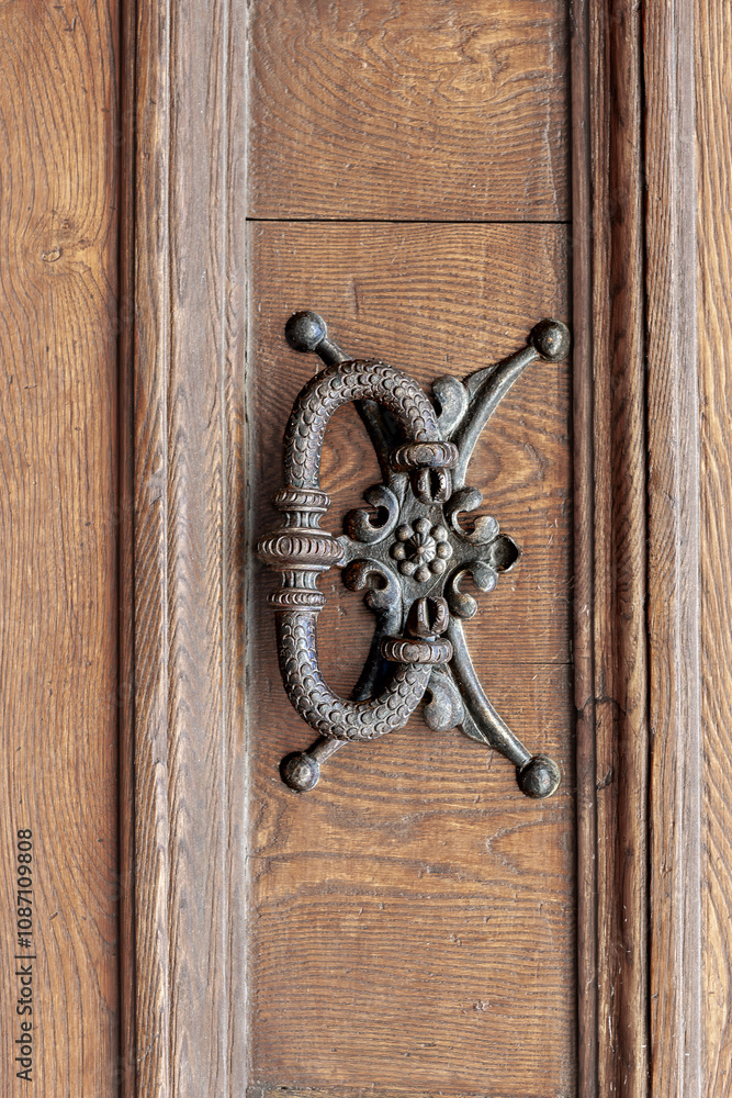 Antique copper door handle from Arezzo in Tuscany, Italy showcasing intricate craftsmanship and historical design elements