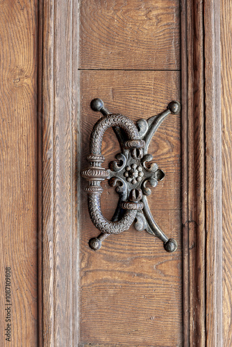 Obraz na płótnie Antique copper door handle from Arezzo in Tuscany, Italy showcasing intricate craftsmanship and historical design elements w salonie