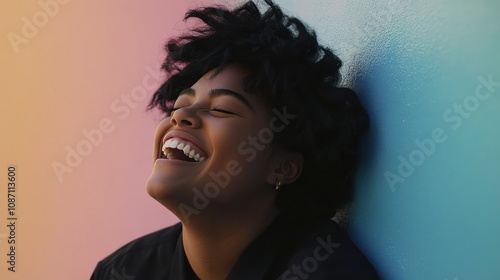 A joyful person laughing against a colorful background.