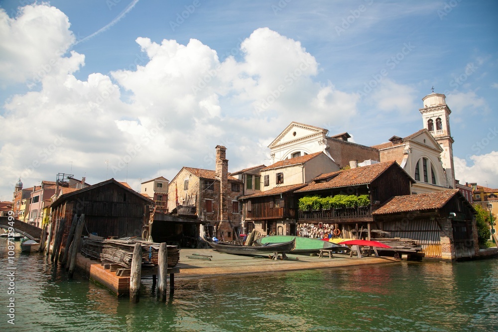 water channel with the gondola's repairman surrounded by architectures in Venice, Italy water channel with the gondola's repairman surrounded by architectures in Venice, Italy