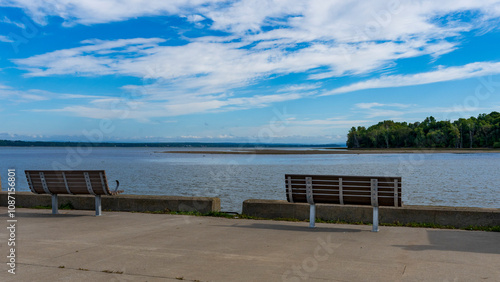 Two benchs looking at the Saint Lawrence river on a blue sky photo