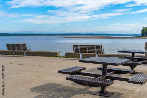 Benches and picnic tables in front of the SaintLawrence river photo