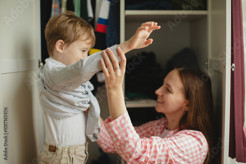 Mother helping her son get ready for school. Good parenting childcare concept. photo