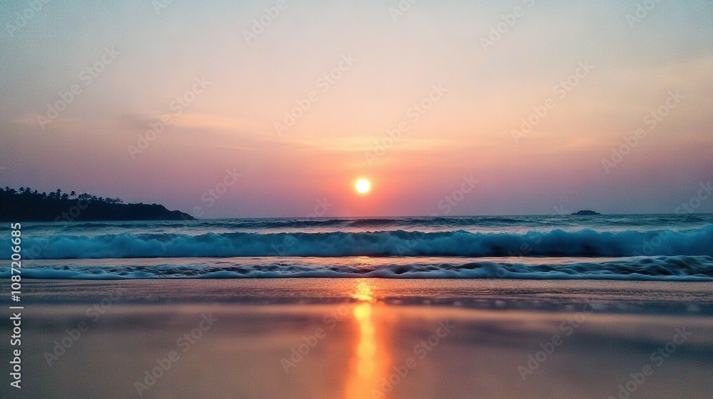 Obraz premium The sun descends on the ocean, casting waves towards the shore as a distant island looms in view