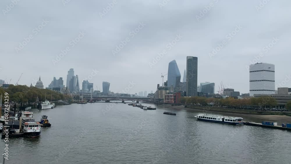 Panoramic, scenic view of London city skyline. St Paul Cathedral and modern high rise buildings. Business, financial district, downtown. Motion of Thames river water. London, United Kingdom Panoramic, scenic view of London city skyline. St Paul Cathedral and modern high rise buildings. Business, financial district, downtown. Motion of Thames river water. London, United Kingdom
