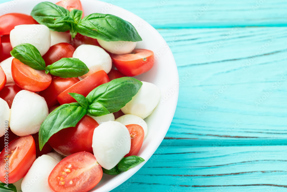 Basil leaves , cherry tomatoes and mozzarella cheese . In bowl food photography Basil leaves , cherry tomatoes and mozzarella cheese . In bowl food photography