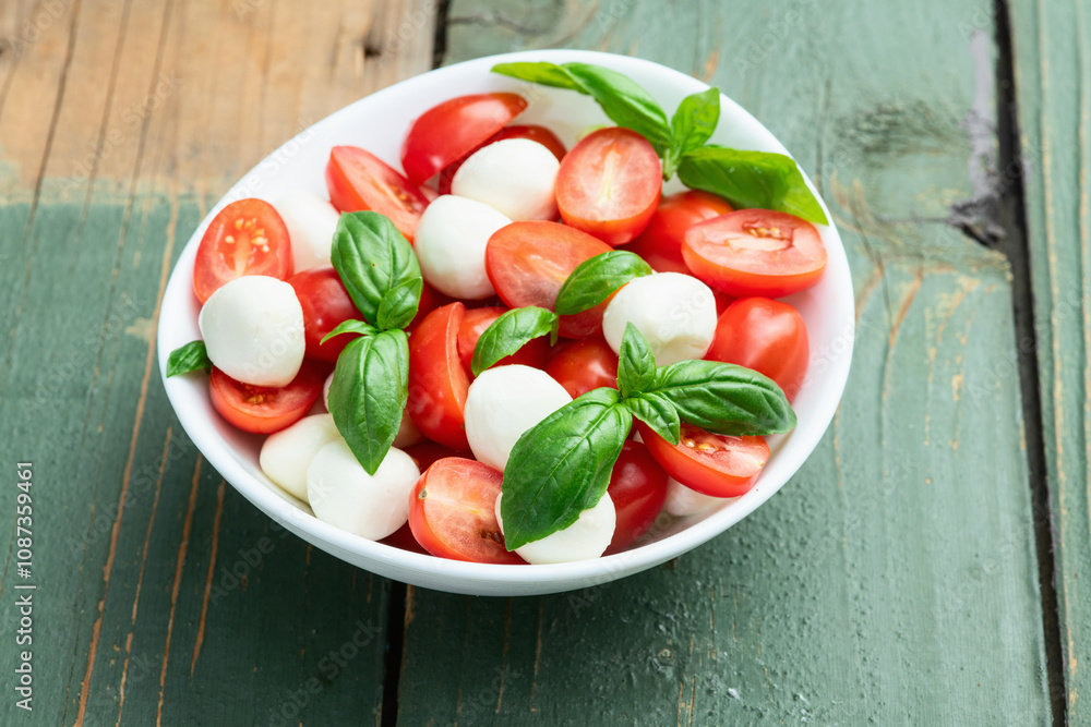 Basil leaves , cherry tomatoes and mozzarella cheese . In bowl food photography Basil leaves , cherry tomatoes and mozzarella cheese . In bowl food photography